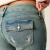 Dżinsy bootcut z niskim stanem, haftem motyla i średnim wypraniem Dżinsy bootcut z niskim stanem, haftem motyla i średnim wypraniem