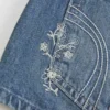 Mini szorty jeansowe z haftowanym kwiatowym wzorem, ultra niskim stanem i średnim odcieniem Mini szorty jeansowe z haftowanym kwiatowym wzorem, ultra niskim stanem i średnim odcieniem