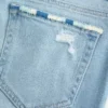 Niskie, postrzępione, jasne dżinsy z haftem i rozszerzanymi nogawkami Niskie, postrzępione, jasne dżinsy z haftem i rozszerzanymi nogawkami
