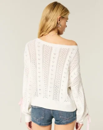Sweter z rękawami z kokardkami i splotem warkoczowym